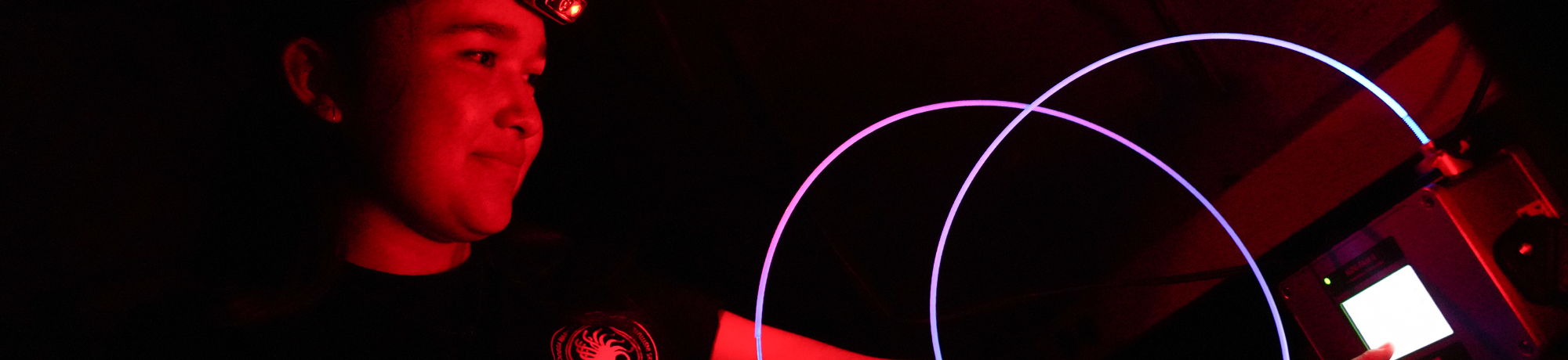 A person uses a glowing string and computer.