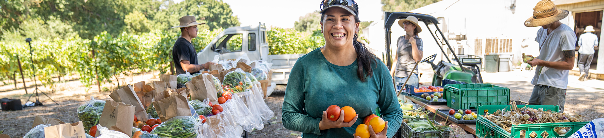 A student carrying vegetables harvested at the Student Farm.