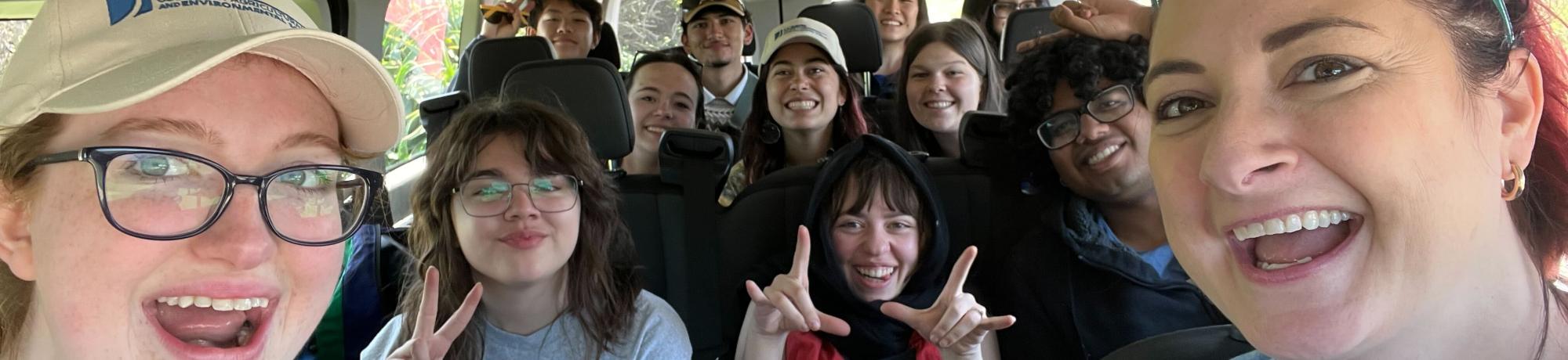 A group of people smiling in a bus together.