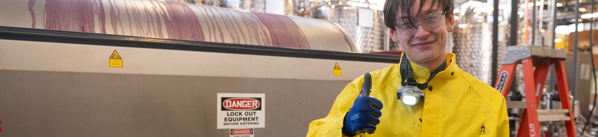 Wolfgang Peterson, a viticulture major, goes into the tank and washes out all the left over grape skin and seeds out for cleaning the grape crusher.